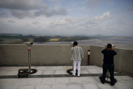 People look at North Korea's propaganda village Kaepoong through binoculars from the top of the Aegibong Peak Observatory, south of the demilitarised zone (DMZ), separating the two Koreas in Gimpo, South Korea, October 5, 2021. 