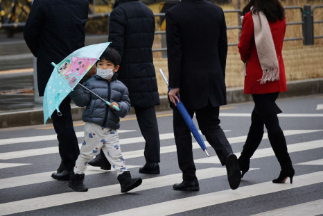 A boy wearing a mask to prevent contracting the coronavirus disease (COVID-19) walks on a zebra crossing in Seoul, South Korea, January 25, 2022.   