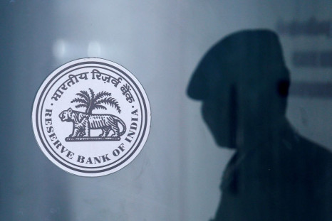 A security guard's reflection is seen next to the logo of the Reserve Bank Of India (RBI) at the RBI headquarters in Mumbai, India, June 6, 2019. 