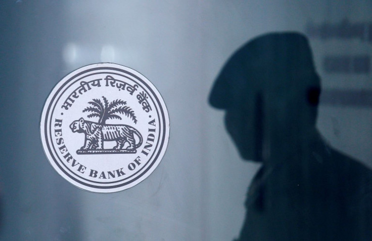 A security guard's reflection is seen next to the logo of the Reserve Bank Of India (RBI) at the RBI headquarters in Mumbai, India, June 6, 2019. 