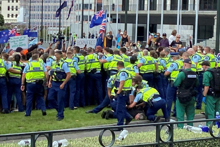 An anti-vaccine mandate protester is detained as people gather to demonstrate in front of the parliament in Wellington, New Zealand, February 10, 2022. 