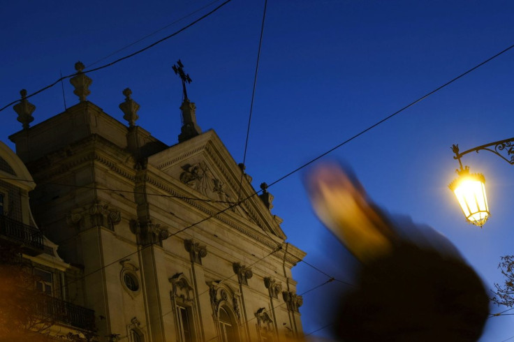 A person walks by a church in the center of Lisbon, Portugal, December 2, 2021. Picture taken with a slow shutter speed.