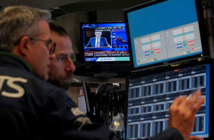 Traders work, as a screen shows Federal Reserve Chairman Jerome Powell's news conference after the U.S. Federal Reserve interest rates announcement, on the floor of the New York Stock Exchange (NYSE) in New York, U.S., October 30, 2019. 