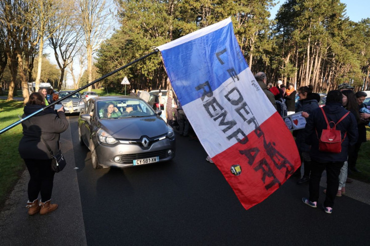 Supporters wave French national flag and cheer French anti-COVID restrictions car drivers near the Canadian National Memorial in Vimy northern France as they parade during the start of their "Convoi de la liberte" (The Freedom Convoy), a vehicular convoy
