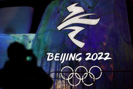A man photographs an illuminated logo ahead of the Beijing 2022 Winter Olympics in Beijing, China January 26, 2022. 
