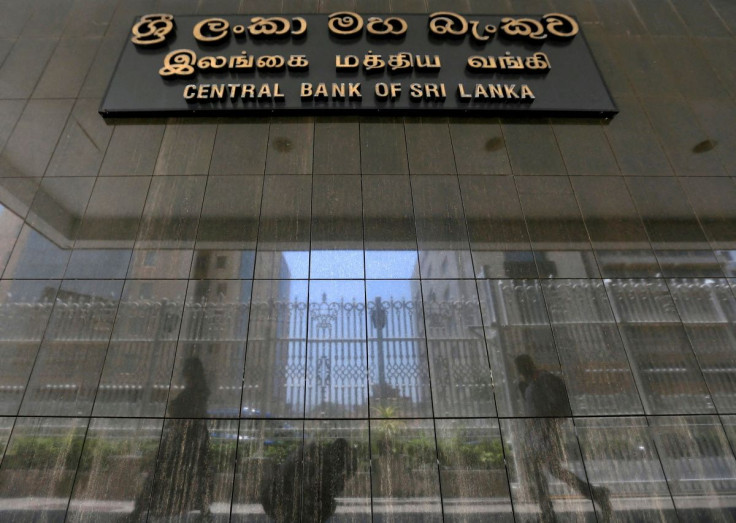 People walk past the main entrance of the Sri Lanka's Central Bank in Colombo, Sri Lanka March 24, 2017. 