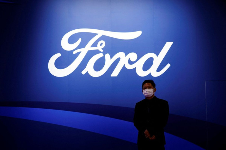 A man stands near the Ford logo during a media day for the Auto Shanghai show in Shanghai, China April 19, 2021.