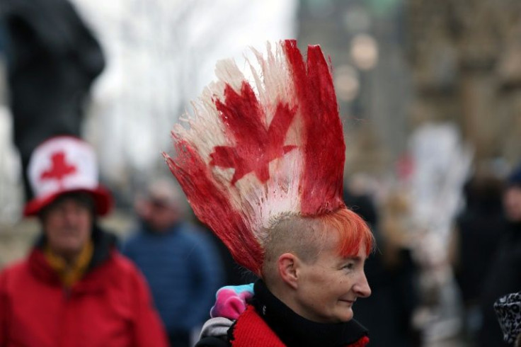 A protester with a Canadian flag painted in her hair walks the line as demonstrators continue to protest the Covid-19 mandates on February 10, 2022 in Ottawa, Canada.