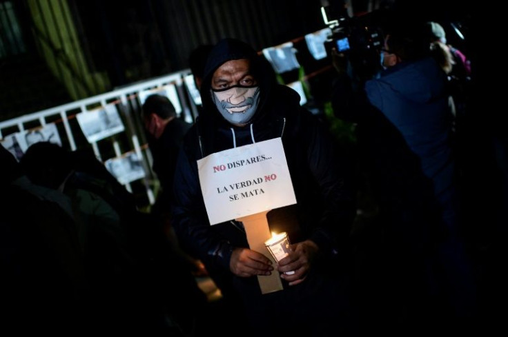 A man holds a sign reading "Do Not Shoot. The Truth Does Not Kill" at a protest against the murders of journalists outside the interior ministry in Mexico City