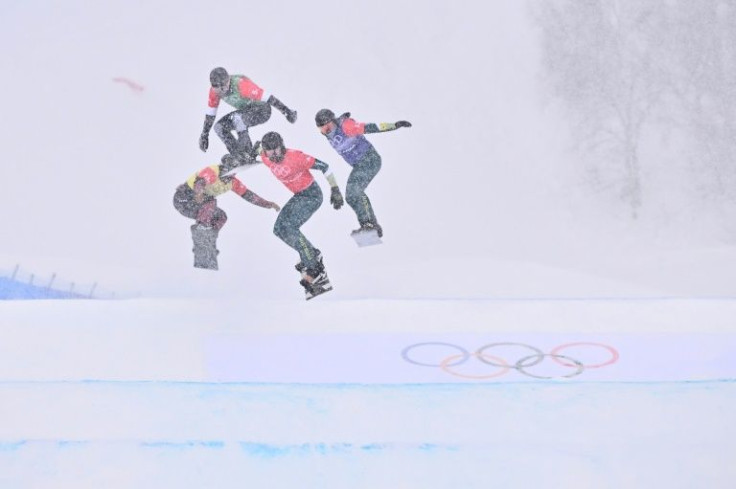 Snow falls on the competitors in the snowboard mixed team cross quarter-finals on Saturday