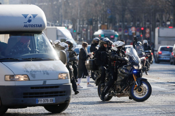 Police officers on motorcycles direct camper vans out of the Champs-Elysees avenue as French drivers and their "Convoi de la liberte" (The Freedom Convoy), a vehicular convoy protest, arrive in Paris to protest against coronavirus disease (COVID-19) vacci