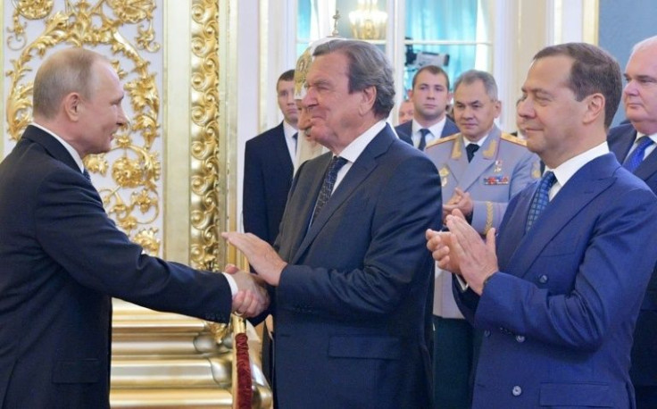 Schroeder shaking hands with Vladimir Putin in Moscow in 2018
