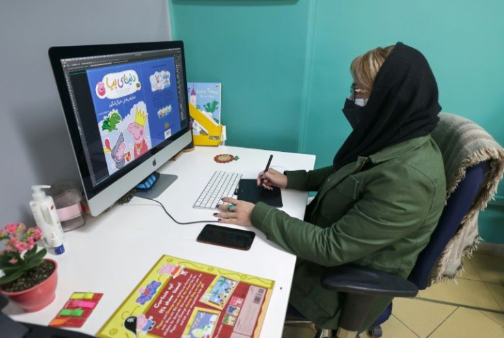 A designer works on a book at Iran's Ofoq publishing house, whose owner said customers will be shocked by the cost of newly-printed volumes