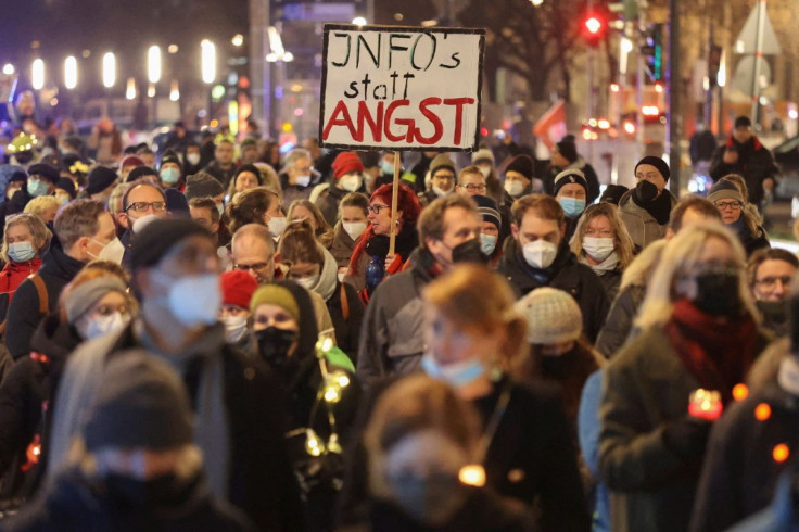 A demonstrator holds a sign that reads "Info instead of fear" during a protest against government measures to curb the spread of the coronavirus disease (COVID-19) in Berlin, Germany, January 24, 2022.