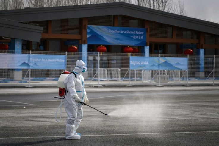 A man in a hazmat suit sprays disinfectant at the Beijing Olympics