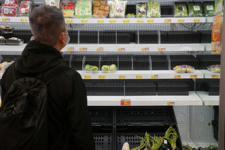 A customer wearing a face mask shops in front of partially empty shelves at a supermarket, following the outbreak of the coronavirus disease (COVID-19), at Sha Tin district, in Hong Kong, China, February 7, 2022. 