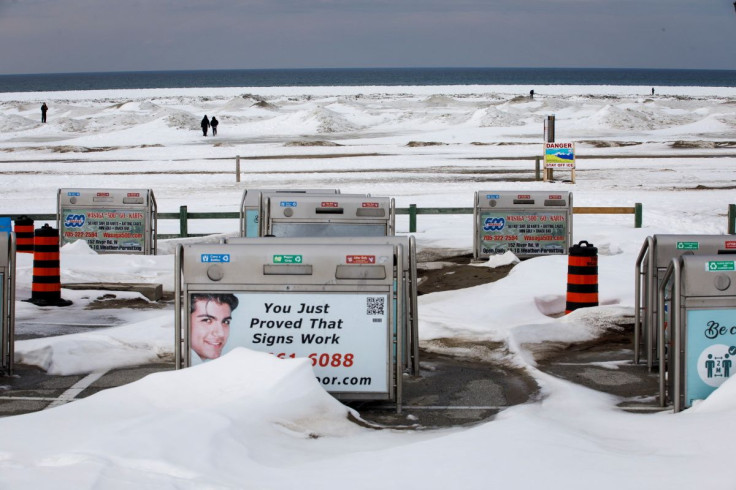 People walk on the frozen beach in Wasaga Beach, Ontario, Canada, February 9, 2022. As young families poured out of some of Canada's major cities, the 2021 census shows smaller communities seeing big growth booms, such as the resort town of Wasaga Beach s