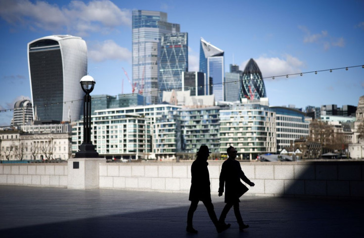 The City of London financial district can be seen as people walk along the south side of the River Thames, amid the coronavirus disease (COVID-19) outbreak in London, Britain, March 19, 2021. 