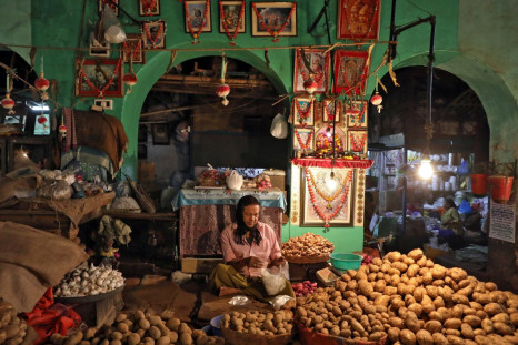 A vendor waits for customers at his shop inside a vegetable market in Kolkata, India, February 12, 2020. 