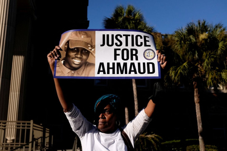 A woman holds a sign outside the Glynn County Courthouse after the jury reached a guilty verdict in the trial of William "Roddie" Bryan, Travis McMichael and Gregory McMichael, charged with the February 2020 death of 25-year-old Ahmaud Arbery, in Brunswic