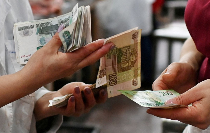 Vendors count Russian rouble banknotes at a market in Omsk, Russia October 29, 2021.