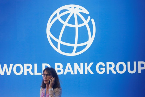 A participant stands near a logo of World Bank at the International Monetary Fund - World Bank Annual Meeting 2018 in Nusa Dua, Bali, Indonesia, October 12, 2018. 