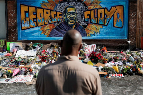 A local resident stands in front of a makeshift memorial honoring George Floyd, at the spot where he was taken into custody, in Minneapolis, Minnesota, U.S., June 1, 2020.  