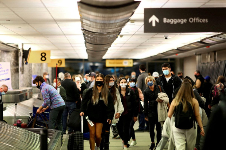 Travelers wearing protective face masks to prevent the spread of the coronavirus disease (COVID-19) reclaim their luggage at the airport in Denver, Colorado, U.S., November 24, 2020.  