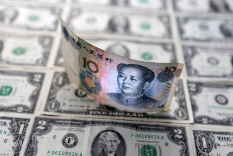 Chinese yuan banknote is displayed on U.S. Dollar banknotes in this illustration taken, February 14, 2022. 