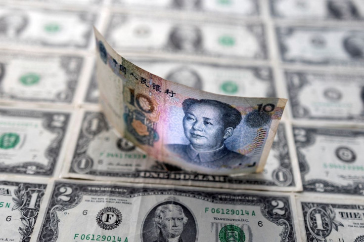 Chinese yuan banknote is displayed on U.S. Dollar banknotes in this illustration taken, February 14, 2022. 