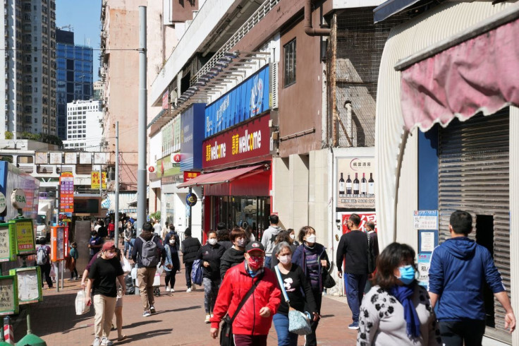 Pedestrians wearing face masks walk on a street, following the coronavirus disease (COVID-19) outbreak in Hong Kong, China February 14, 2022.