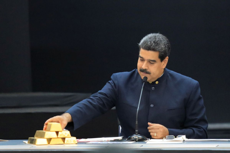 Venezuela's President Nicolas Maduro touches a gold bar as he speaks during a meeting with the ministers responsible for the economic sector at Miraflores Palace in Caracas, Venezuela March 22, 2018.