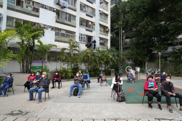 People wearing face masks wait for their swab samples to be collected at a makeshift testing site for the coronavirus disease (COVID-19), following the outbreak in Hong Kong, China February 15, 2022.