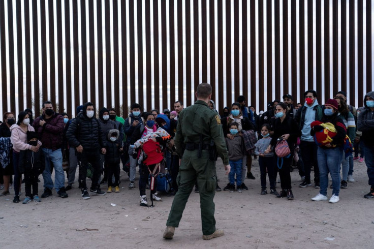 Migrants seeking asylum in the U.S. stand by the border fence while waiting to be processed by the U.S. border patrol after crossing the border from Mexico at Yuma, Arizona, U.S., January 22, 2022.