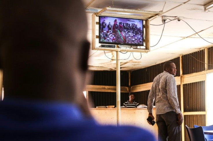 Customers at a coffee shop in Ouagadougou watch the inauguration on national television