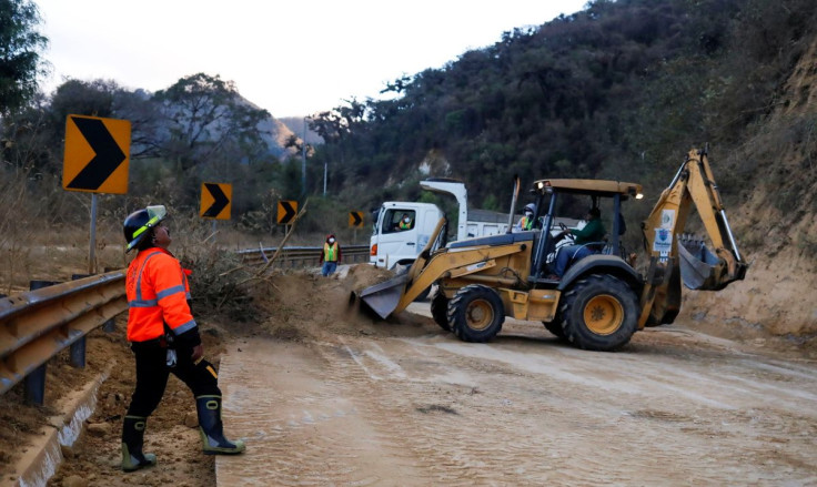 Workers remove debris after a landslide and a fallen tree blocking a road following an earthquake that hit southwestern Guatemala, near Antigua, Guatemala February 16, 2022.