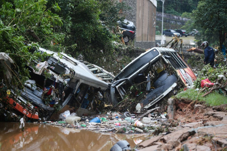 A man observes damaged public buses at a river after pouring rains in Petropolis, Brazil, February 16, 2022.