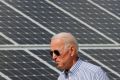 U.S. President Joe Biden walks past solar panels when he was still a candidate touring the Plymouth Area Renewable Energy Initiative in Plymouth, New Hampshire, U.S., June 4, 2019.   