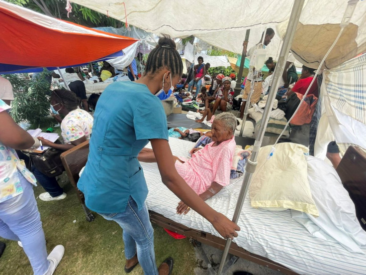 A woman is attended to by a member of the medical personnel outside a hospital after Saturday's 7.2 magnitude quake, in Les Cayes, Haiti August 16, 2021.