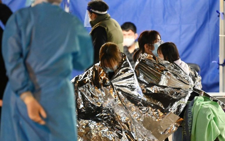 Dozens of people waited outdoors in space blankets at the Caritas Medical Centre in Hong Kong