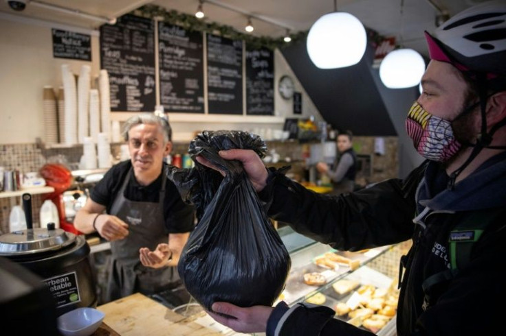 Staff with Upcircle, a British cosmetic company creating skincare products with leftover natural ingredients, collect used coffee grounds for repurposing in south London