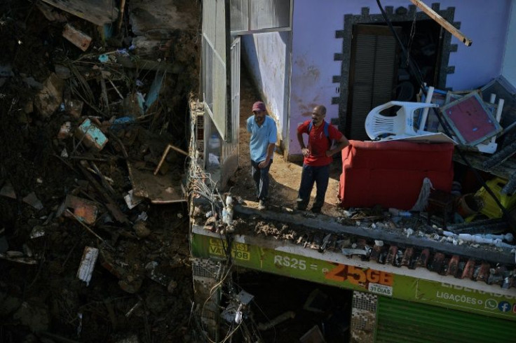 Residents look out over a scene of destruction during the second day of operations at the scene of a mudslide in Petropolis, Brazil on February 17, 2022