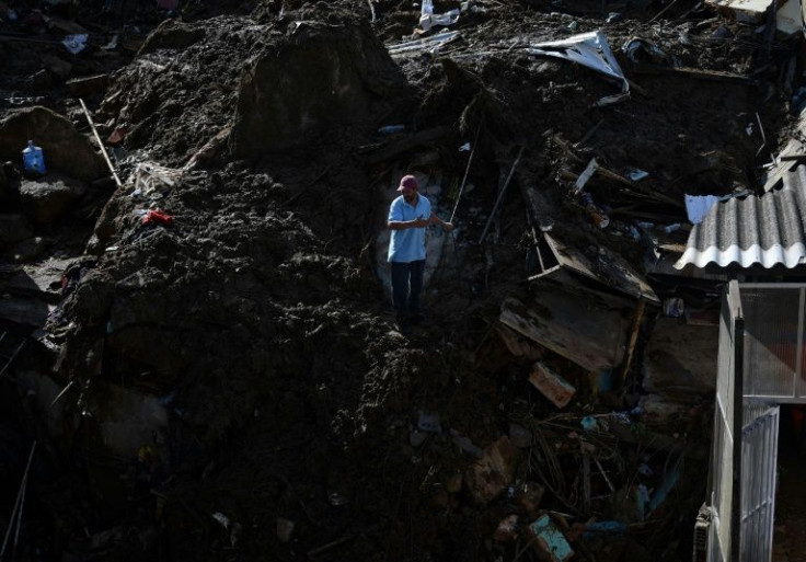 A resident looking for survivors talks to members of a rescue team at the scene
