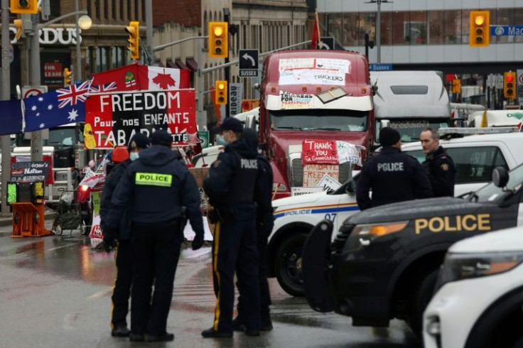 Police officers stand watch in downtown Ottawa as demonstrators continue to protest vaccine mandates and air other grievances on February 17, 2022