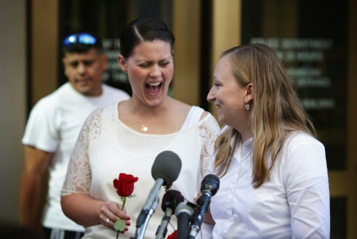 Erika Turner (R) and Jennifer Melsop (2nd R) of Centreville, Virginia, rejoice as they becomes the first same sex marriage couple in Arlington County as they speak to members of the media outside Arlington County Courthouse