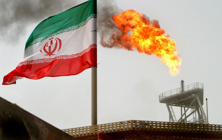 A gas flare on an oil production platform is seen alongside an Iranian flag in the Gulf July 25, 2005. 