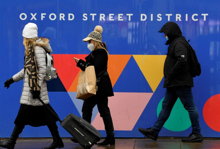 Shoppers wearing protective masks walk on Oxford Street, as rules on wearing face coverings in some settings in England are relaxed, amid the spread of the coronavirus disease (COVID-19) pandemic, in London, Britain January 27, 2022. 