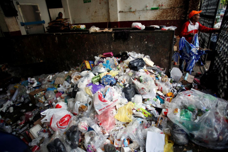 A man stands next to a pile of plastic garbage at a market which no longer provides plastic bags for customers to carry products, in Mexico City, Mexico January 2, 2020.  