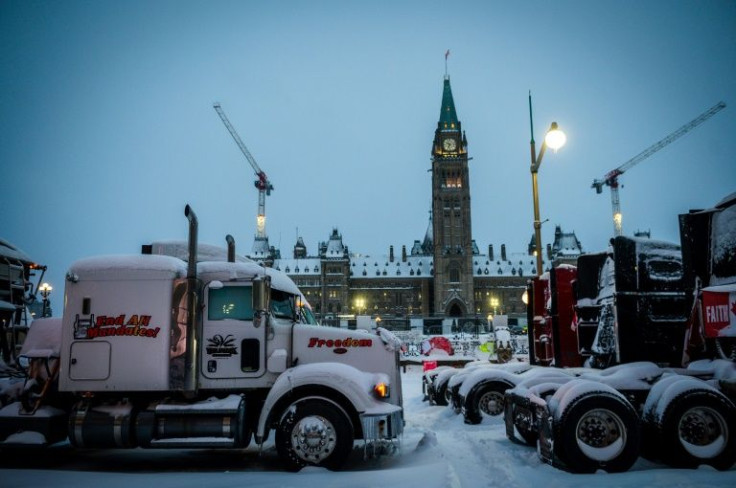 Big rigs block the street in front of Canada's Parliament as police move in to clear the protest against Covid-19 health rules