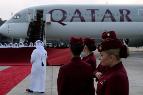 Qatar Airways cabin crew stand in front of an Airbus A350-1000 at Hamad International Airport in Doha, Qatar, February 21, 2018. 